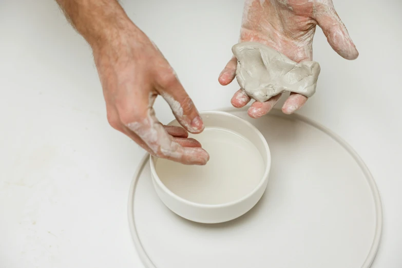 there are two hands that are putting soing in the bowl