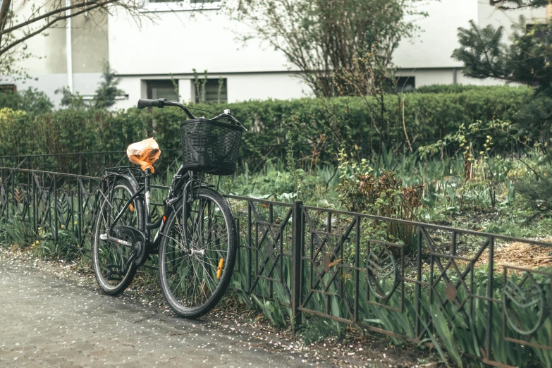 two bicycles parked next to a metal fence