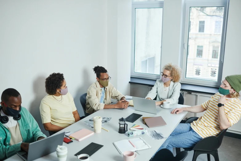 a group of people at a table looking at a laptop