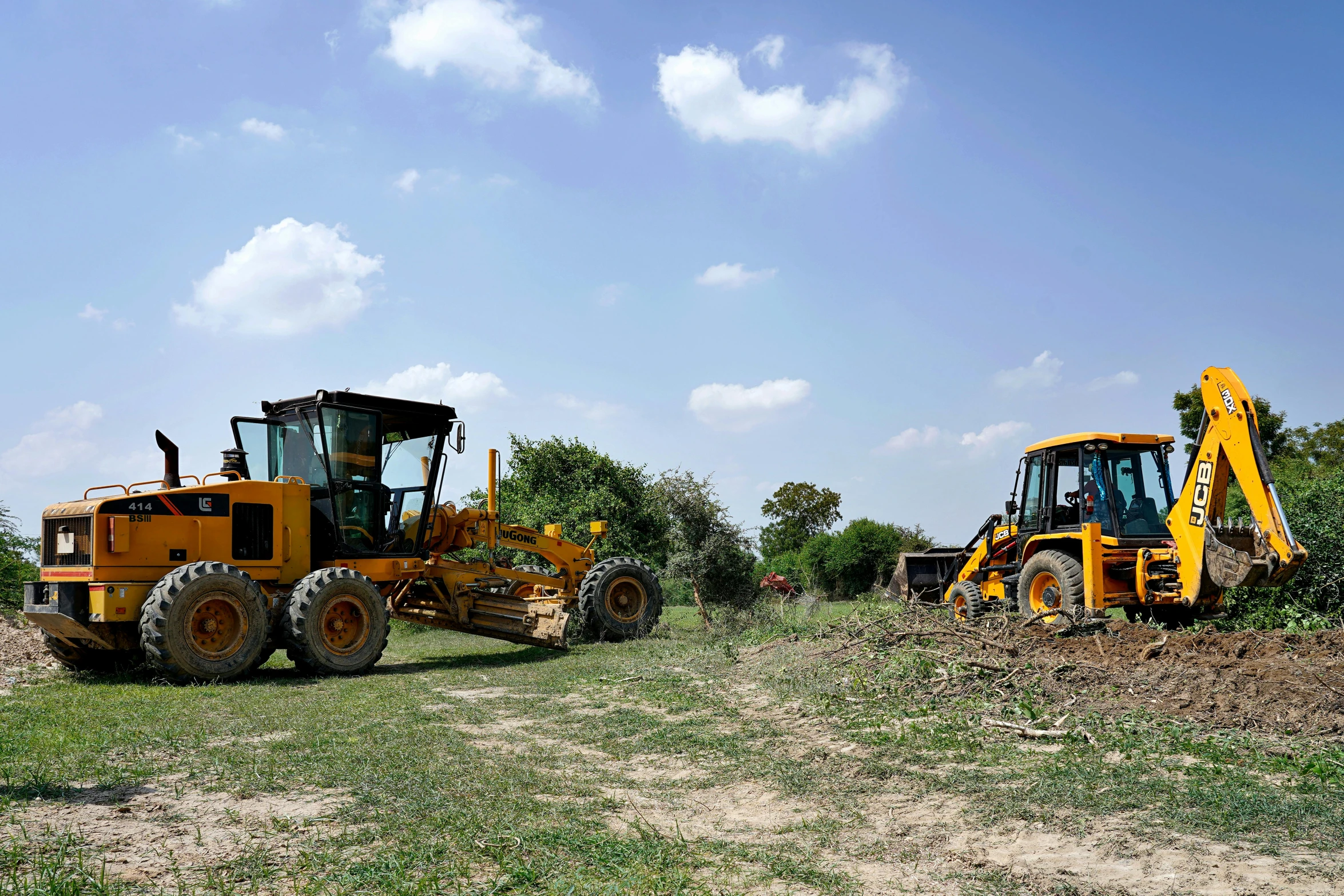 tractor and bulldozer parked in the grass