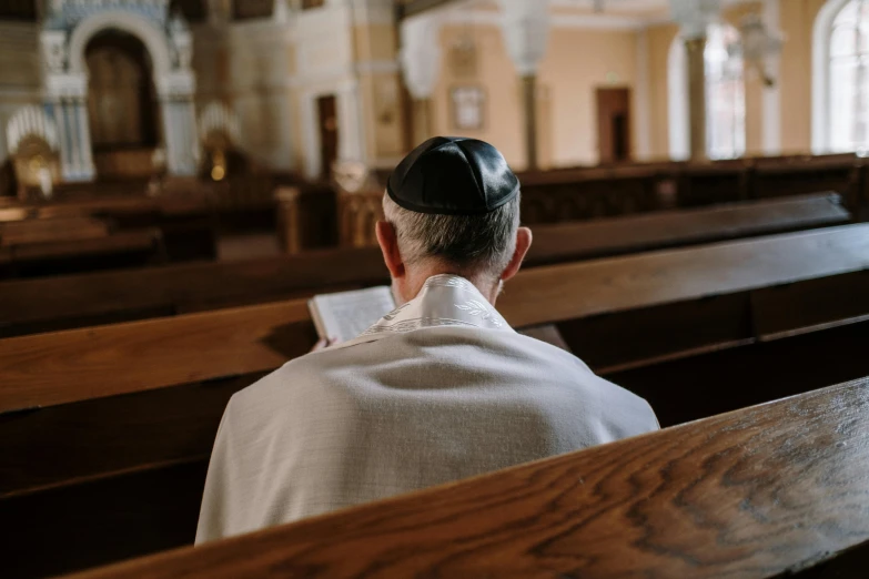 a man sitting down in the pews of an old church