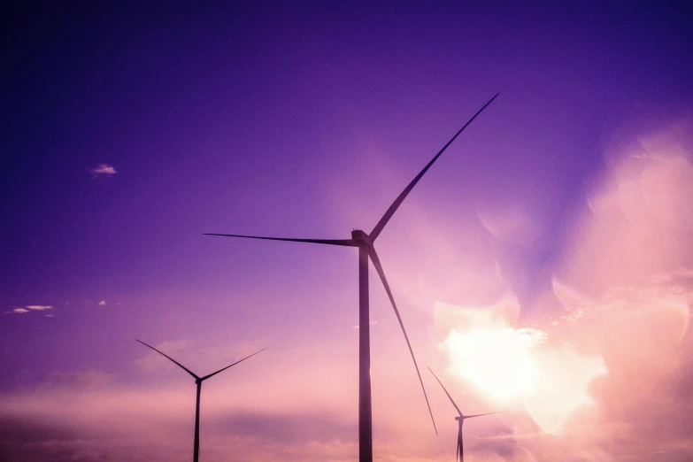 a few wind mills blowing on the side of a field