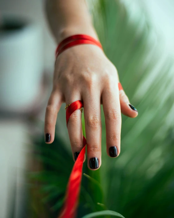 a woman holding her ring up to the sky and pulling it off