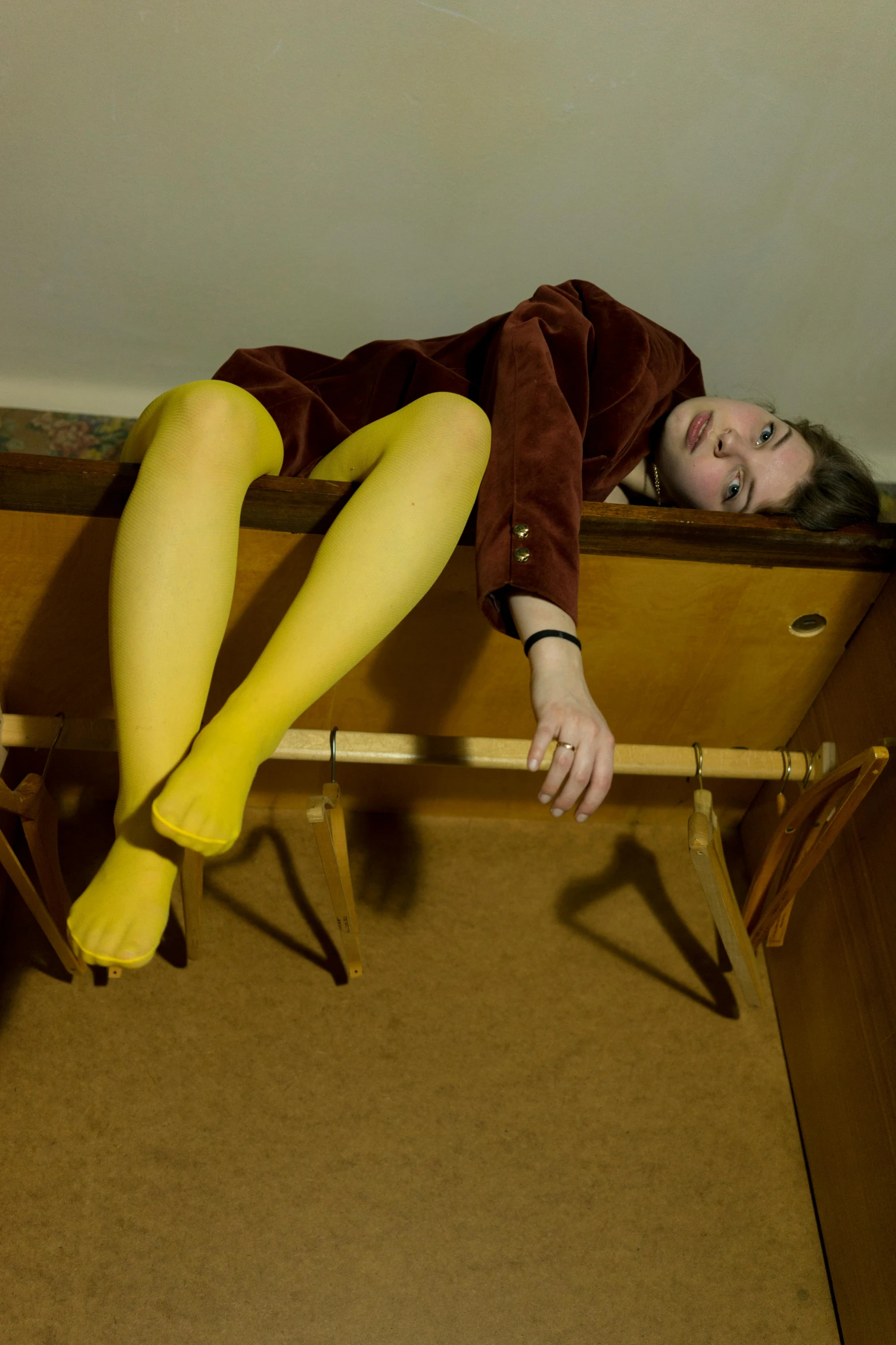 the woman in yellow tights is resting on her bed