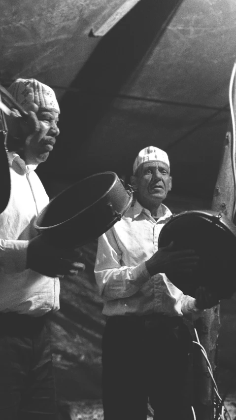 a black and white pograph of a man using a drum