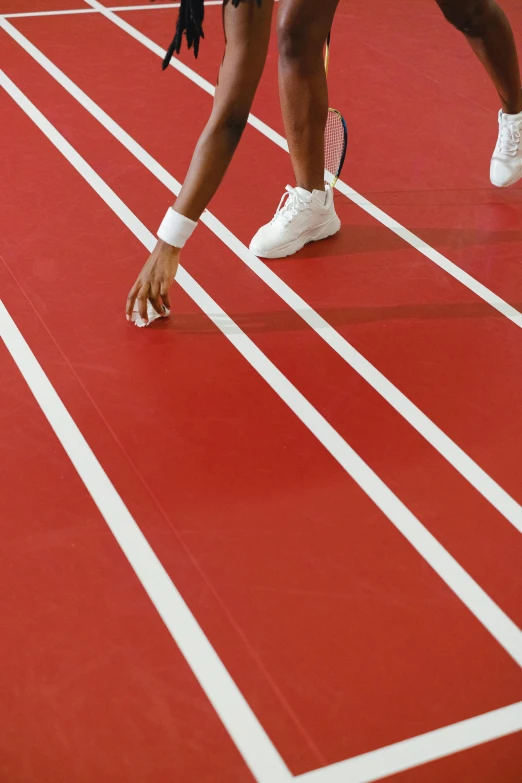 a tennis player is running across a red court