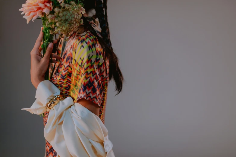 a person with flowers on their head is holding up some cloth