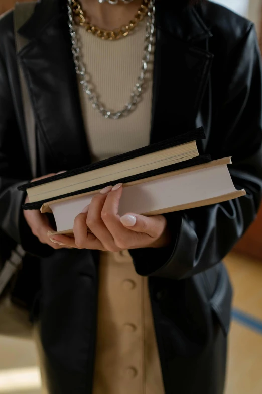 a person holding an open book next to some pearls