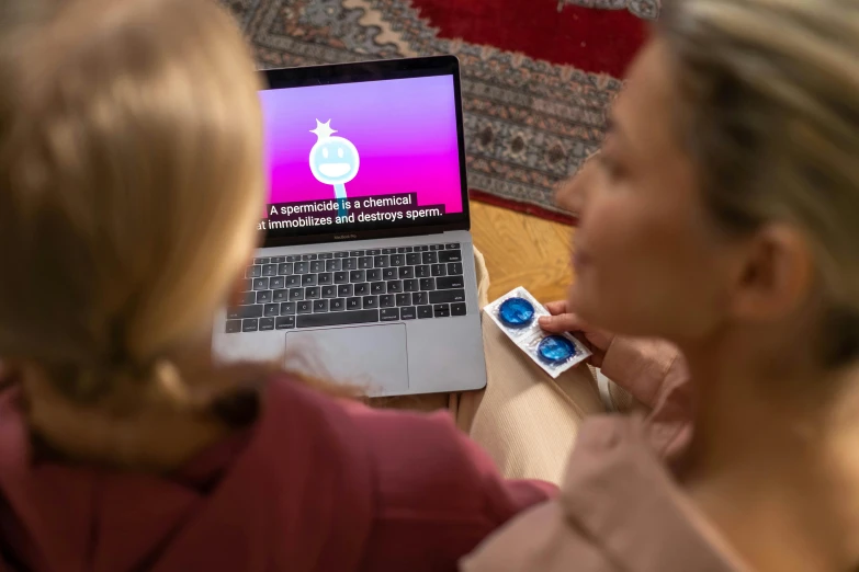 a woman is checking out a laptop on the floor