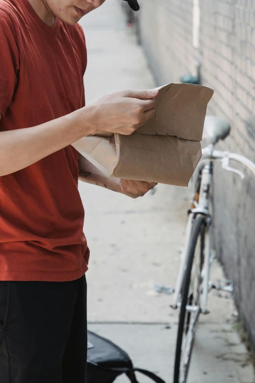 a man is holding a box in one hand and wearing a cap on the other