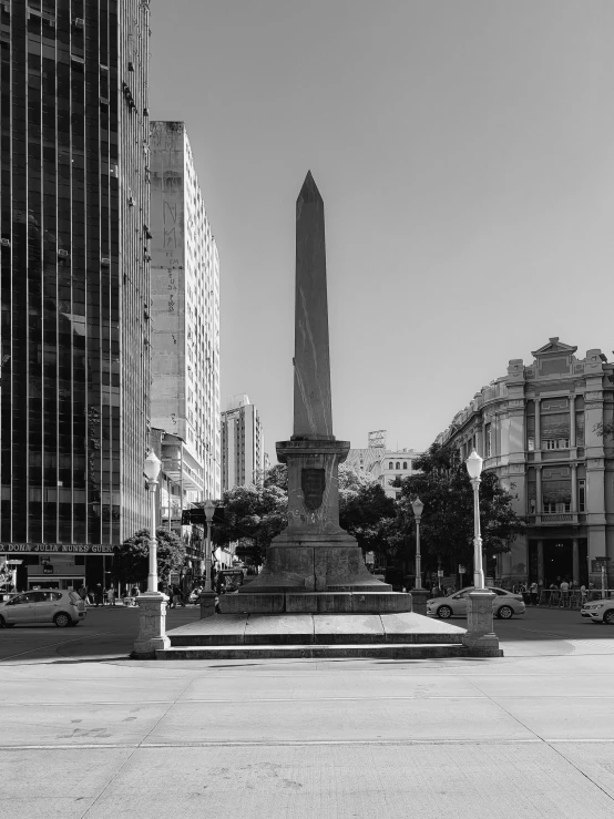 some tall buildings and a small statue in a plaza