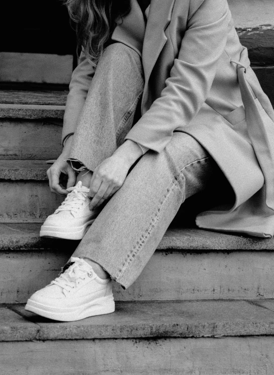 a black and white po of a girl sitting on some steps