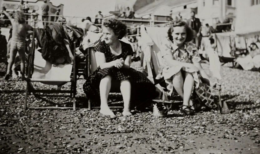 an old po of people seated on the beach