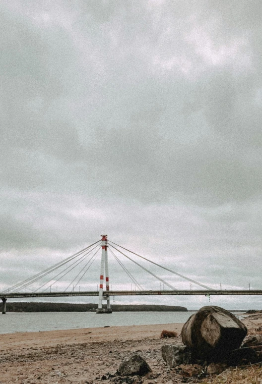 the tall bridge over the ocean is next to a beach