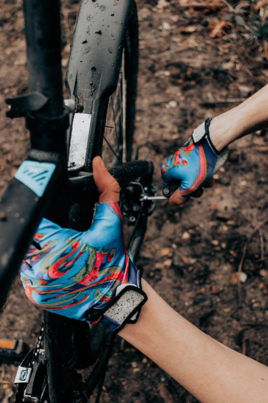 a close up of two people working on a bicycle