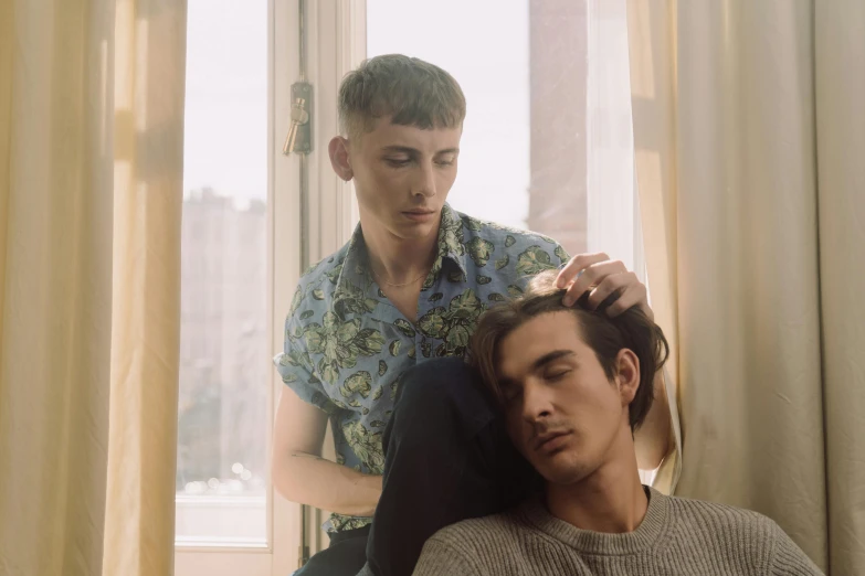 a young man getting his haircut by another young man