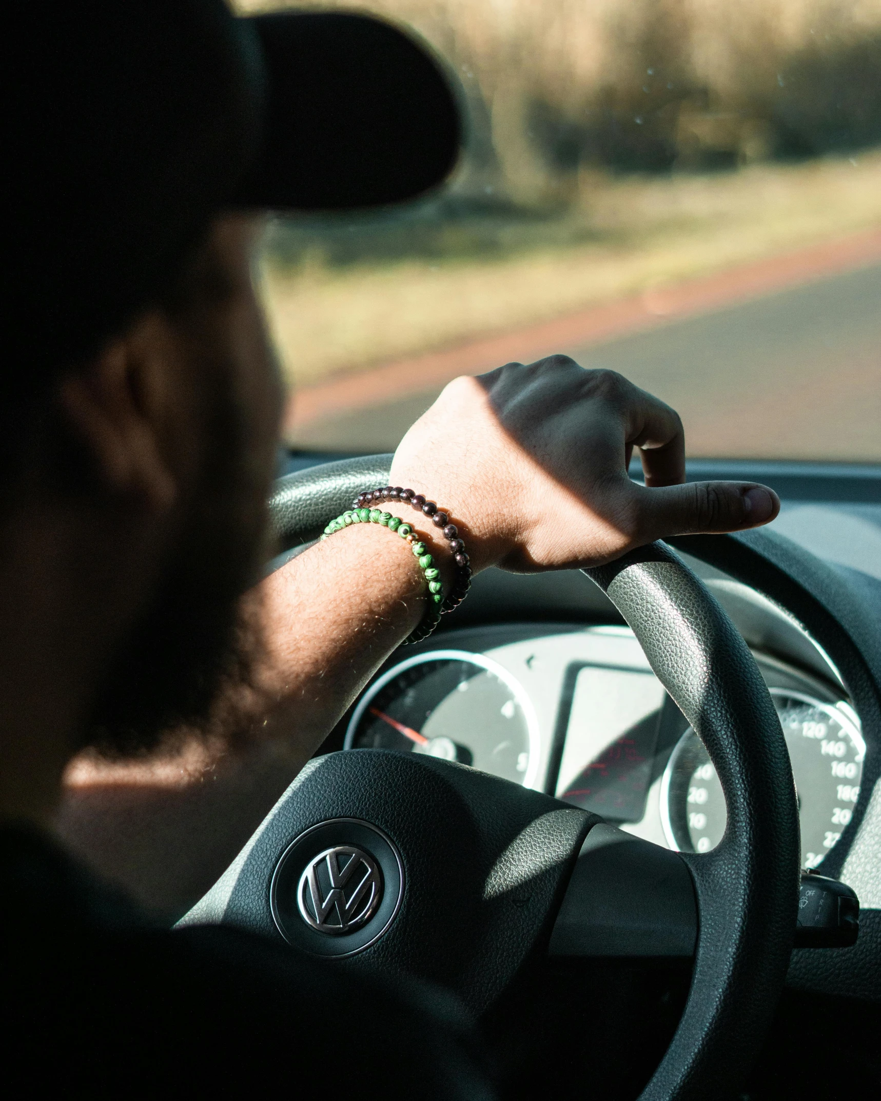 person steering a car on the side of a road