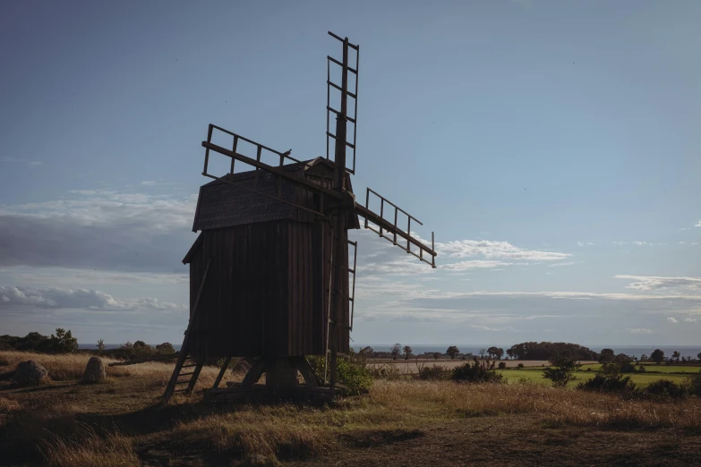 a wooden structure with metal railings and a large wind mill in the distance