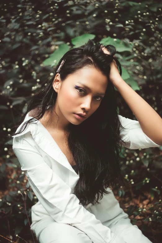 a woman with long hair sitting on the ground