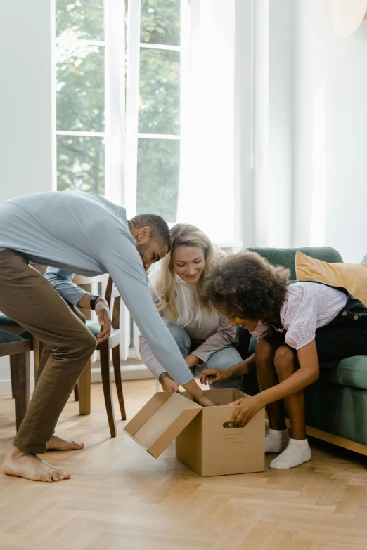 group of young adults packing up items for moving into their new home