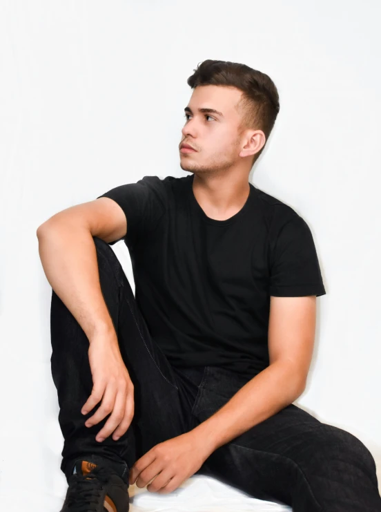 a man wearing black pants sitting on the floor