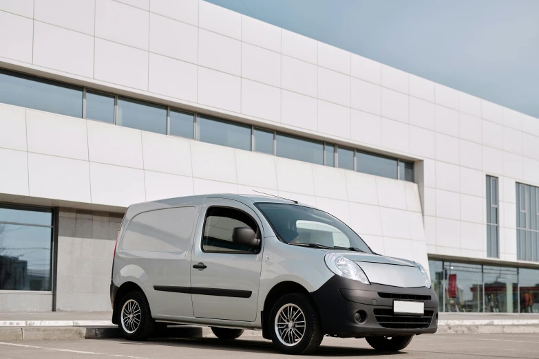 the small van is parked outside of a building