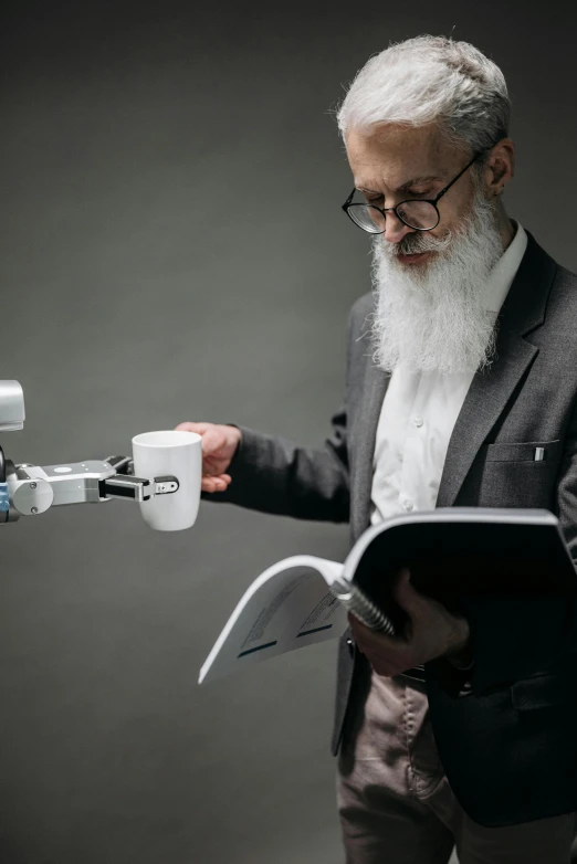 a man with a large long white beard is looking at soing with a tablet