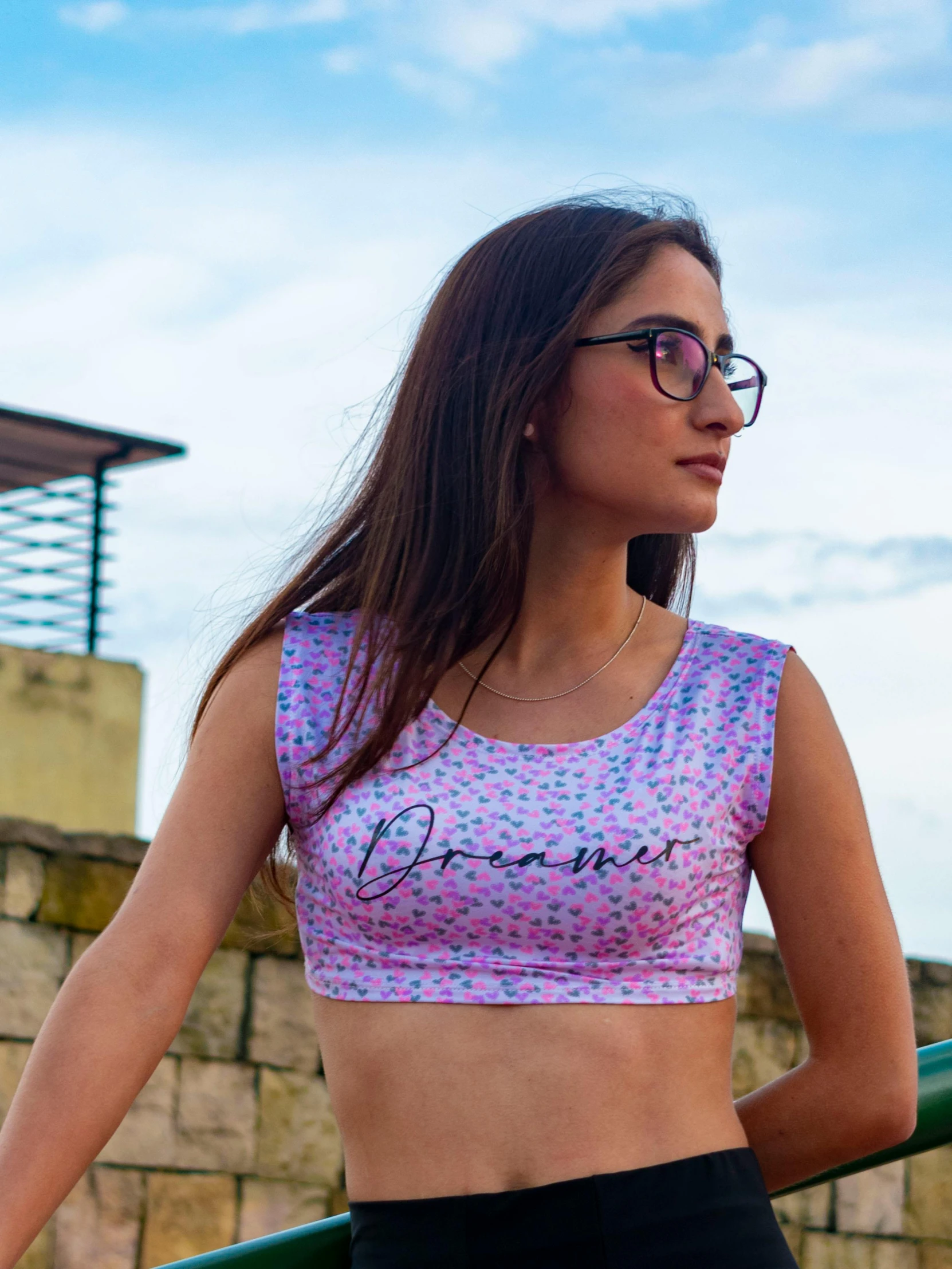 a woman with glasses and a crop top posing