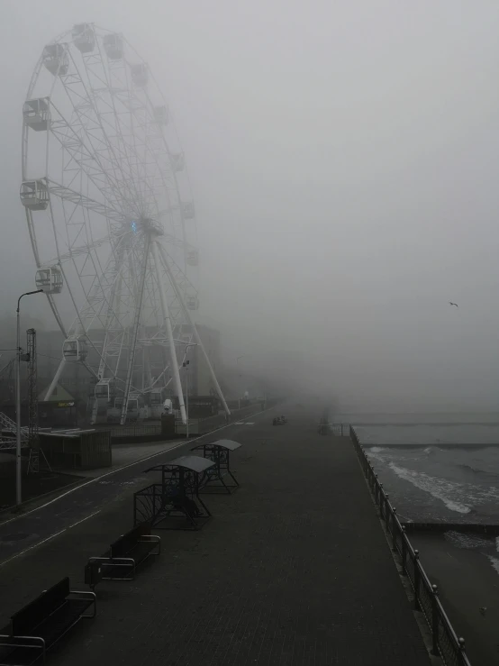 a big wheel in the middle of a street in the fog