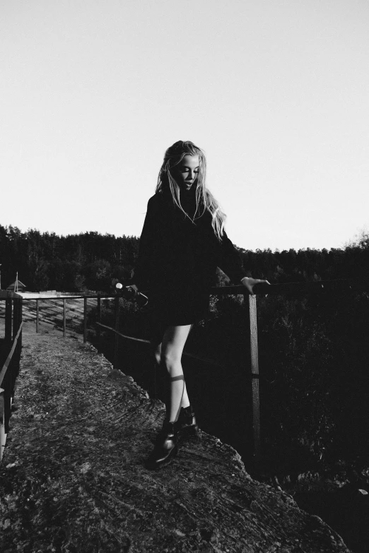 a woman stands on top of a hill