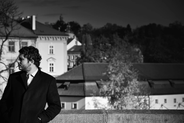 a man looking over his shoulder while leaning on a wall