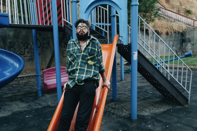 a man standing in front of a slide in a playground