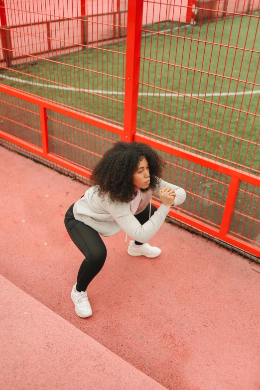 a girl stretching on the steps outside her soccer field