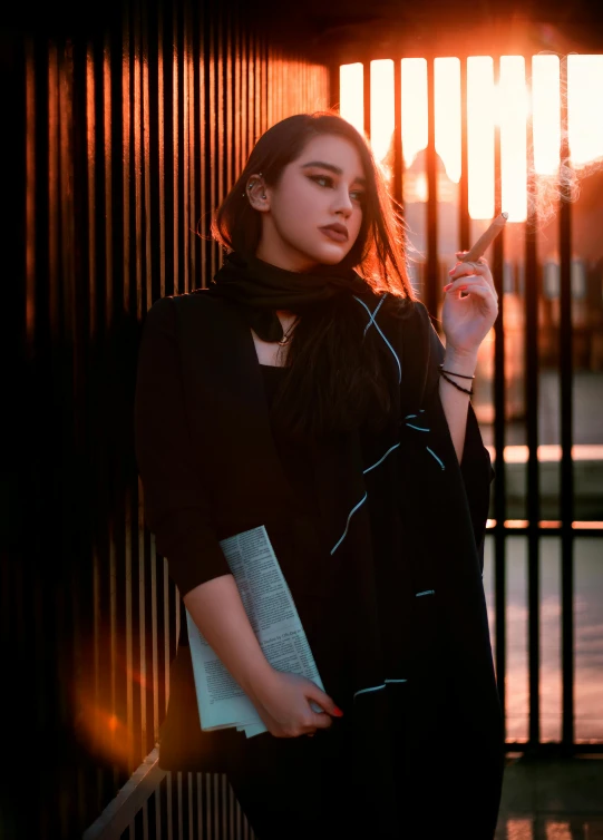 woman posing in front of a fence with her hand on her hip