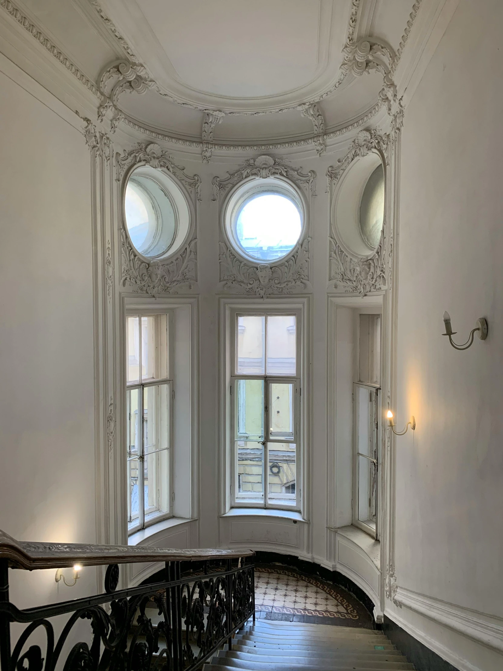 a circular window in a white building on a balcony