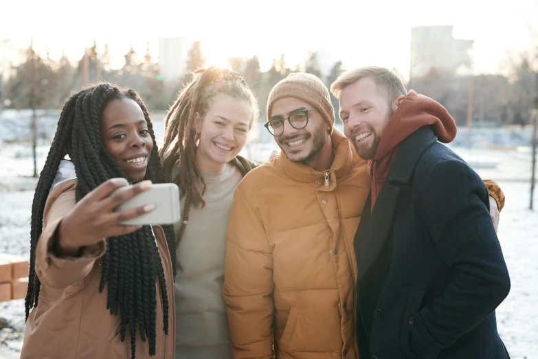 three people are taking a po with their cell phone