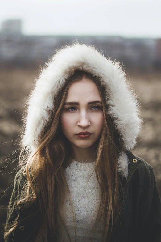 a woman in a coat and hat posing for a po