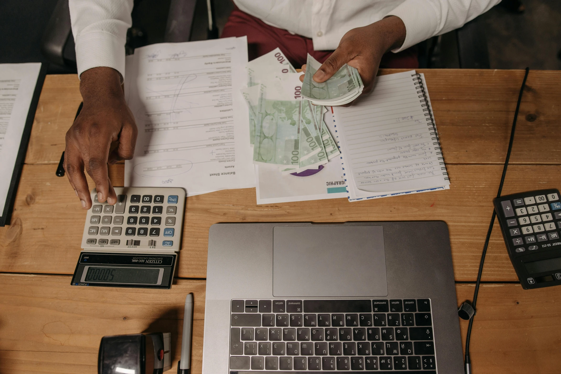 a woman sitting at a desk holding a calculator