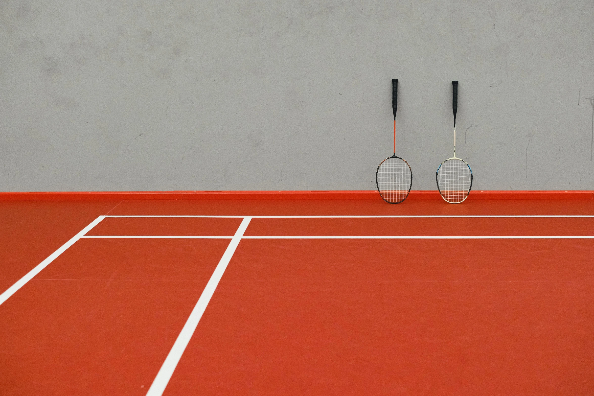 a tennis court with red clay and two black objects