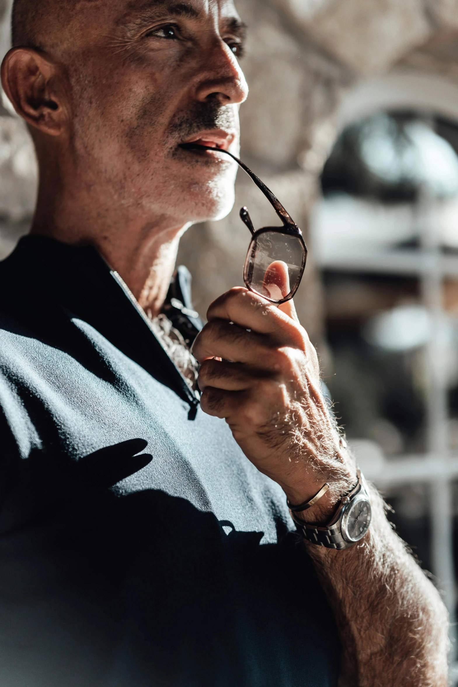 a man in a suit looking away while holding a cigarette