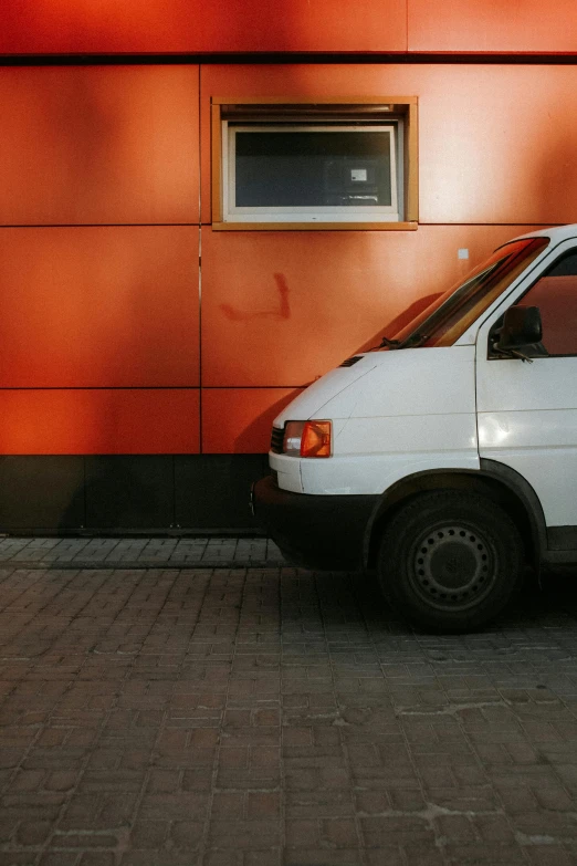 a white van parked against a wall in front of a house