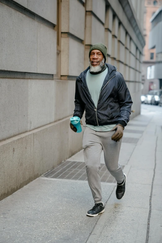 an older man jogging along the street with water bottle in hand