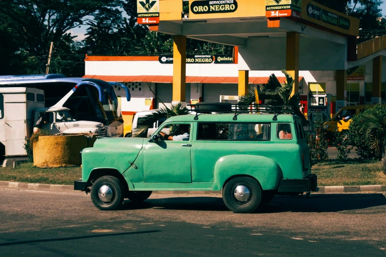 a green pickup truck at a gas station