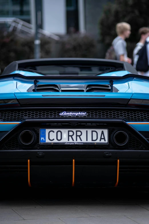 the front end of a sports car that is blue and black