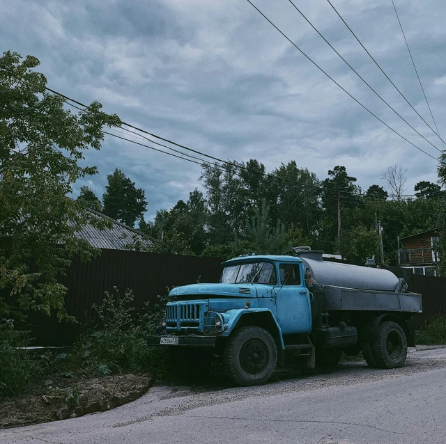 a blue truck parked on the side of the road