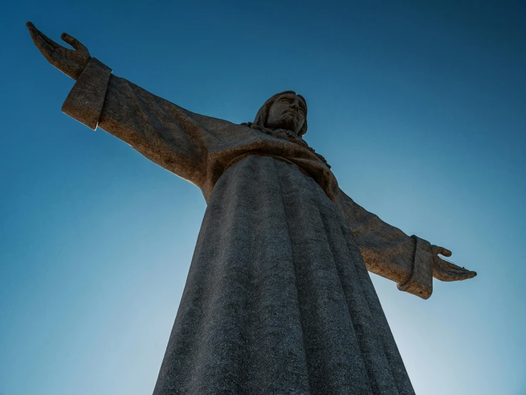 a large statue of jesus in front of the sky