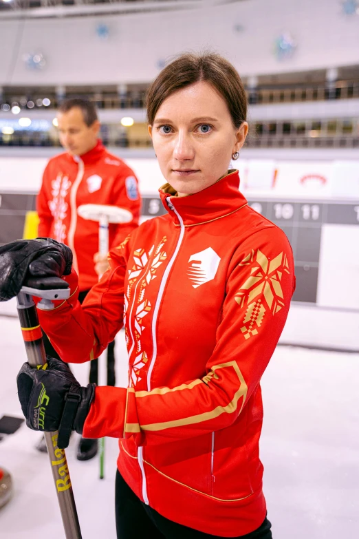 woman in red with ski equipment posing for the camera