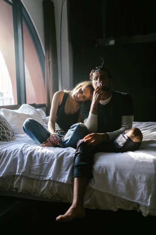 a man is sitting on a bed with a woman