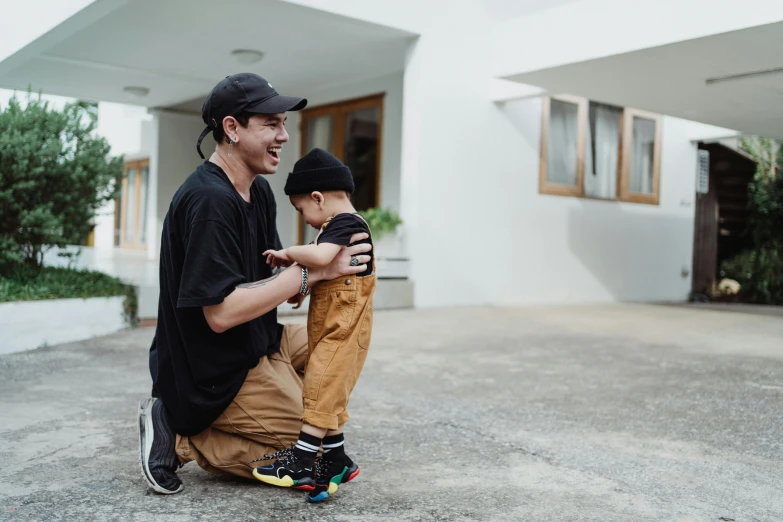 two boys laughing at each other while sitting in the street