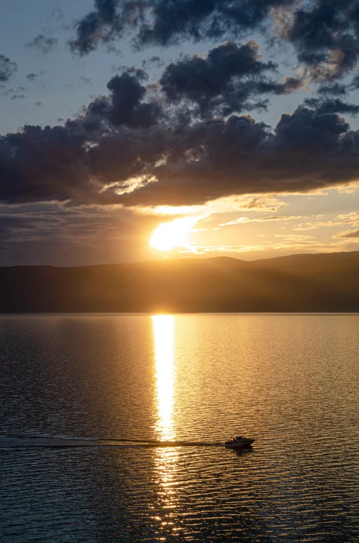 the sun rises over an empty lake in the distance